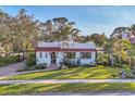 Charming Mediterranean-style home with a red tile roof, lush landscaping, and a well-manicured lawn at 1864 Clematis St, Sarasota, FL 34239