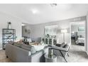 Open living room with gray sofas and a view of a bedroom at 21192 Winside Ave, Port Charlotte, FL 33952