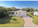 An aerial view showcasing a charming house, well-manicured lawn, and driveway at 2711 Larkspur Dr, Punta Gorda, FL 33950