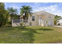 Nice yellow house with a covered porch, palm trees, and a large yard at 2711 Larkspur Dr, Punta Gorda, FL 33950