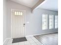 Bright entryway with a white front door, light gray walls, tile flooring, and natural light streaming through the windows at 31 Bunker Pl, Rotonda West, FL 33947