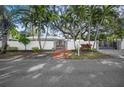 Front view of a white house with a gated entrance and brick walkway at 3331 Old Oak Dr, Sarasota, FL 34239