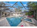 Relaxing pool and spa with screened enclosure, outdoor kitchen, and lounge chairs at 3331 Old Oak Dr, Sarasota, FL 34239