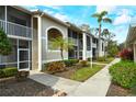 Condo building exterior with lush landscaping at 5250 Hyland Hills Ave # 1525, Sarasota, FL 34241