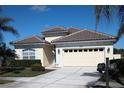 One-story house with tile roof, two-car garage, and landscaped yard at 5452 Club View Ln, North Port, FL 34287