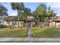 Home exterior with a well-maintained lawn and various shade trees along the walkway to the front door at 5616 Mashie Cir, North Port, FL 34287