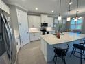 Modern kitchen featuring white cabinets, quartz countertops, and stainless steel appliances at 649 Maraviya Blvd, Nokomis, FL 34275