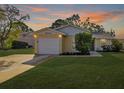 Inviting yellow house with a white garage door and landscaped lawn at 6507 36Th Avenue W Dr, Bradenton, FL 34209