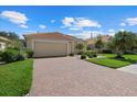 Tan house with a large driveway and well-maintained landscaping at 6841 74Th Street E Cir, Bradenton, FL 34203