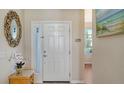 Bright and airy entryway with a mirror and orchid plant at 6920 74Th Street E Cir, Bradenton, FL 34203