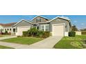 Two-story house with gray siding, beige garage doors, and manicured landscaping at 1115 116Th E St, Bradenton, FL 34212