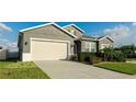 Two-story house with gray siding, beige garage door, and neatly landscaped yard at 1115 116Th E St, Bradenton, FL 34212