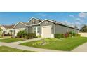 One-story house with gray siding, beige garage door, and well-maintained landscaping at 1115 116Th E St, Bradenton, FL 34212
