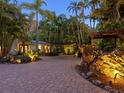 Landscaped front yard with tropical plants and a brick driveway leading to the house entrance at 1330 N Lockwood Ridge Rd, Sarasota, FL 34237