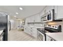 Stylish kitchen with stainless steel appliances, granite countertops, and light wood-look flooring at 14820 Rue De Bayonne # 308, Clearwater, FL 33762