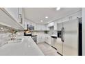 Updated kitchen features stainless steel appliances, light gray backsplash, and granite countertops at 14820 Rue De Bayonne # 308, Clearwater, FL 33762