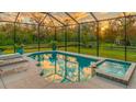 Relaxing pool and spa surrounded by a screened-in enclosure offers beautiful sunset views at 16307 29Th E Ct, Parrish, FL 34219