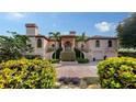 Grand two-story home with a lush, landscaped front yard and circular driveway leading to the entrance at 279 Robin Dr, Sarasota, FL 34236