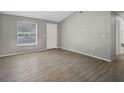 Living room with gray walls, wood-look tile floors, and vaulted ceiling at 3110 Elmer St, Sarasota, FL 34231