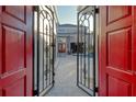 Grand entrance with elegant iron gates, leading to a beautiful courtyard, and a glimpse of the home's architecture at 3580 Fair Oaks Ln, Longboat Key, FL 34228