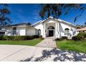 Front view of a white house with a portico and landscaped yard at 3649 Wilderness W Blvd, Parrish, FL 34219