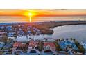 Aerial view of a luxurious waterfront home with a private dock, surrounded by beautiful landscaping and serene waters at 400 N Washington Dr, Sarasota, FL 34236