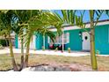 Teal house with palm trees, white door, and seating area on the porch at 4010 18Th W Ave, Bradenton, FL 34205