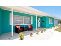 Front porch with teal exterior, white shutters, and two wicker chairs at 4010 18Th W Ave, Bradenton, FL 34205