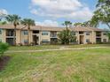 Tan two-story building with balconies, lush landscaping, and palm trees at 4049 Crockers Lake Blvd # 23, Sarasota, FL 34238