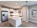 Spacious kitchen with stainless steel appliances, a central island with a white countertop, and gray flooring at 4739 Willow Bend Ave, Parrish, FL 34219