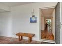 Inviting entryway with wood bench and view into the condo at 5055 Gulf Of Mexico Dr # 411, Longboat Key, FL 34228