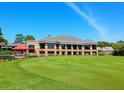 Large clubhouse with expansive windows overlooking a putting green at 5244 Marsh Field Rd # 6, Sarasota, FL 34235