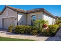 Close up shot of a well landscaped home with a manicured lawn and paver driveway at 5814 Cavano Dr, Sarasota, FL 34231