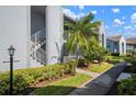 Exterior view of a townhome featuring well-manicured landscaping, a stairway, and a light post at 6609 Stone River Rd # 206, Bradenton, FL 34203