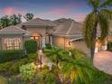 Elegant home with a welcoming entrance and lush landscaping at dusk at 7033 Brier Creek Ct, Lakewood Ranch, FL 34202