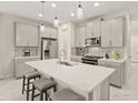 Spacious kitchen boasts modern gray cabinets, white quartz countertops, and stainless steel appliances at 8669 Rain Song Rd, Sarasota, FL 34238