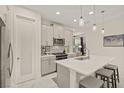 Modern kitchen with gray cabinets, white quartz countertops, and stainless steel appliances at 8669 Rain Song Rd, Sarasota, FL 34238