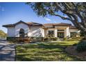 Single-story home with tile roof, manicured landscaping, and a long driveway at 1060 Water Oak Ne Ct, St Petersburg, FL 33703