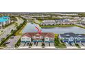 Aerial view showcasing the townhome community and a tranquil lake at 11630 Woodleaf Dr, Bradenton, FL 34211