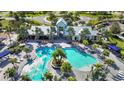 Aerial view of a community pool featuring a zero entry point, palm trees, and ample seating at 11794 Little River Way, Parrish, FL 34219