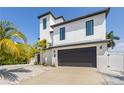 Modern two-story home with a dark gray garage door and white exterior at 130 Burns Rd, Terra Ceia, FL 34250