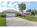 Tan house with white garage door and neatly landscaped yard at 1364 Berkshire Ct, Venice, FL 34292