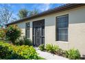 House exterior featuring a screened entryway and lush landscaping at 1410 Maseno Dr, Venice, FL 34292