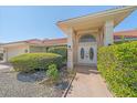 A close-up of the front entrance featuring an arched window, a pathway, and manicured shrubbery at 1426 Landview Ln, Osprey, FL 34229