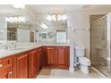 Tiled bathroom with double sinks, marble countertops, and a glass shower at 17278 Acapulco Rd # 312, Punta Gorda, FL 33955