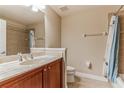 Neutral tiled bathroom featuring a light vanity with marble counters and a shower-tub combo at 17278 Acapulco Rd # 312, Punta Gorda, FL 33955