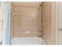 Neutral tiled shower-tub combo with shower head and soap dish at 17278 Acapulco Rd # 312, Punta Gorda, FL 33955