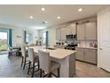 Modern kitchen with gray cabinets, quartz countertops, and an island at 17723 Gulf Ranch Pl, Lakewood Ranch, FL 34211