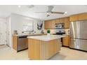 Bright kitchen with stainless steel appliances, wooden cabinets, and a central island for meal preparation at 2321 Terry Ln, Sarasota, FL 34231