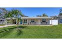 Inviting single-story home featuring a lush green lawn and a cozy seating area on the front porch at 3302 21St Avenue W Dr, Bradenton, FL 34205